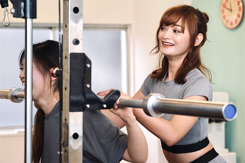 アップルジム武蔵小杉店のジム画像・女性のお客様と女性トレーナーのトレーニング（スクワット）風景