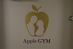 Apple GYM（アップルジム）高田馬場店の入り口ドアにはロゴが装飾されています。